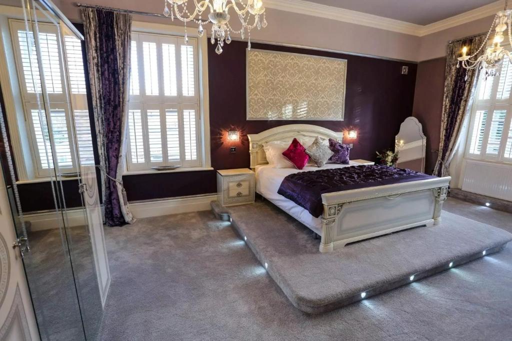 a bedroom with a bed and a chandelier at Derby Manor in Bournemouth