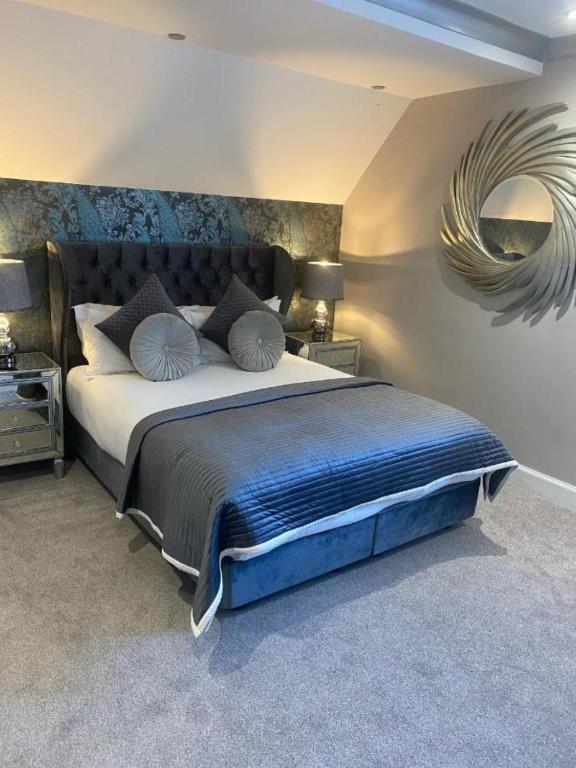 a bedroom with a large bed and a mirror at Derby Manor in Bournemouth