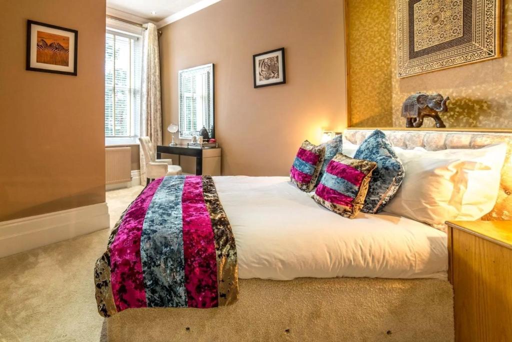 a bedroom with a large bed with pillows on it at Derby Manor in Bournemouth