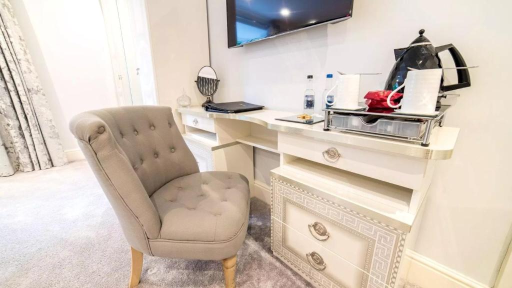a desk with a chair next to a dresser at Derby Manor in Bournemouth
