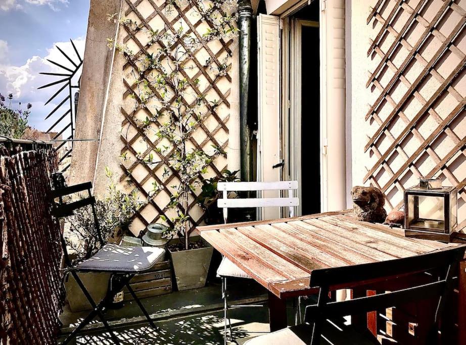 une table et des chaises en bois assises sur une terrasse dans l'établissement Loft de charme Louvre Tuileries Palais Royal, à Paris