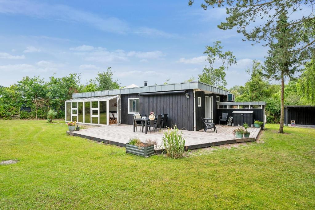 a tiny house with a deck in a yard at Awesome Home In Knebel With 2 Bedrooms And Internet in Ebeltoft