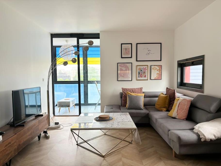 un salon avec un canapé et une télévision dans l'établissement Appartement 2 voyageurs à proximité des gares, à Lille