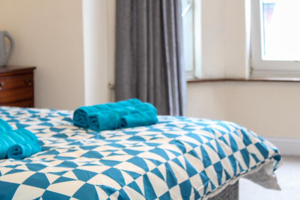 a blue and white bed with blue pillows on it at Darwin road guest house 3 in Southampton