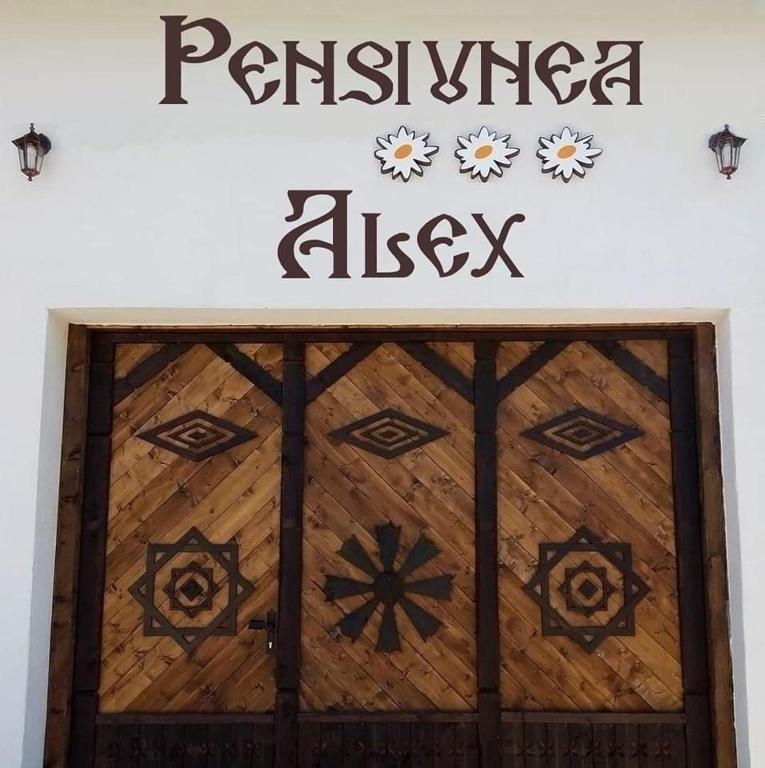 a wooden door with a sign on top of it at Pensiunea Alex in Marga