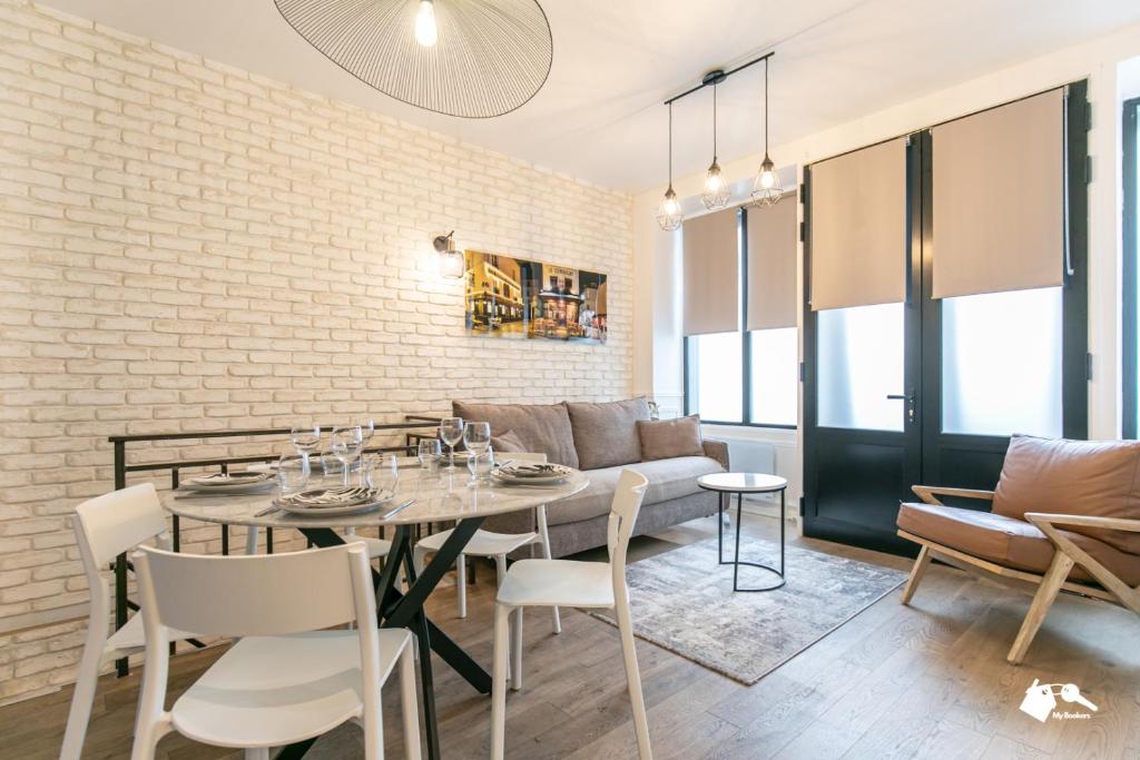 une salle à manger avec une table et un canapé dans l'établissement MBA - Cavalloti Splendide Appartement, à Paris