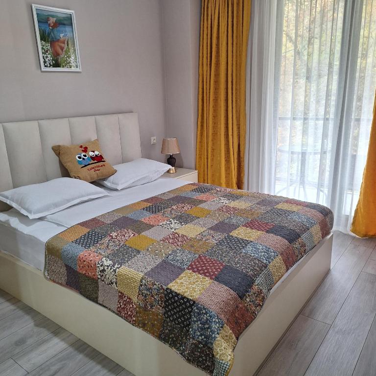 un lit avec une couette dessus dans une chambre dans l'établissement Likani - 407, à Bordjomi
