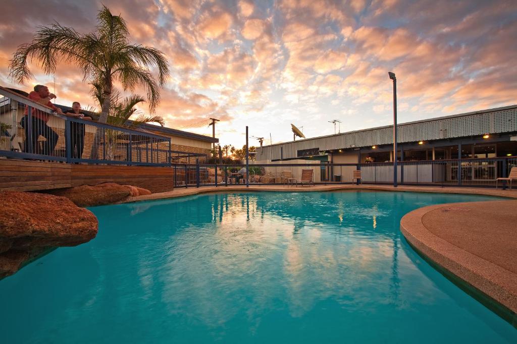 a large blue swimming pool in front of a building at Potshot Hotel Resort in Exmouth