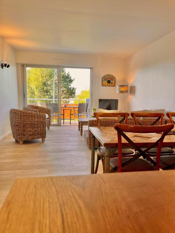 une chambre avec des chaises, des tables et une grande fenêtre dans l'établissement Grenouille, à Dinard