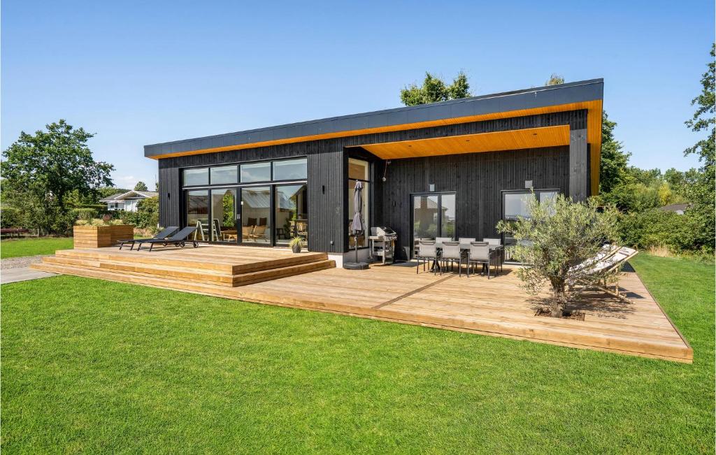 a black house with a wooden deck in a yard at Beach Front Home In Haderslev in Haderslev