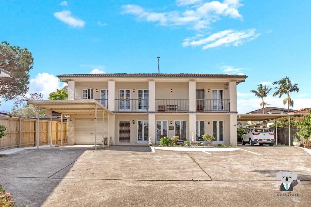 an exterior view of a house with a driveway at KozyGuru | Thornleigh | Charming Two-Bed Townhouse in Thornleigh