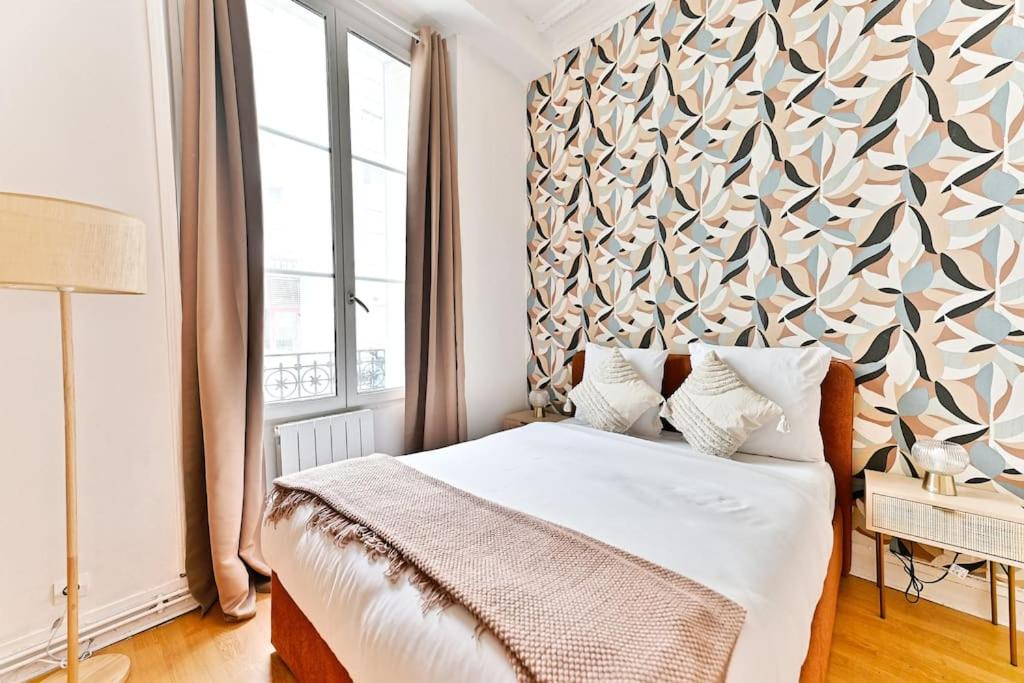 - une chambre avec un grand lit et un grand mur dans l'établissement Magnifique appartement Neuf Rose Paris 14ème - II, à Paris