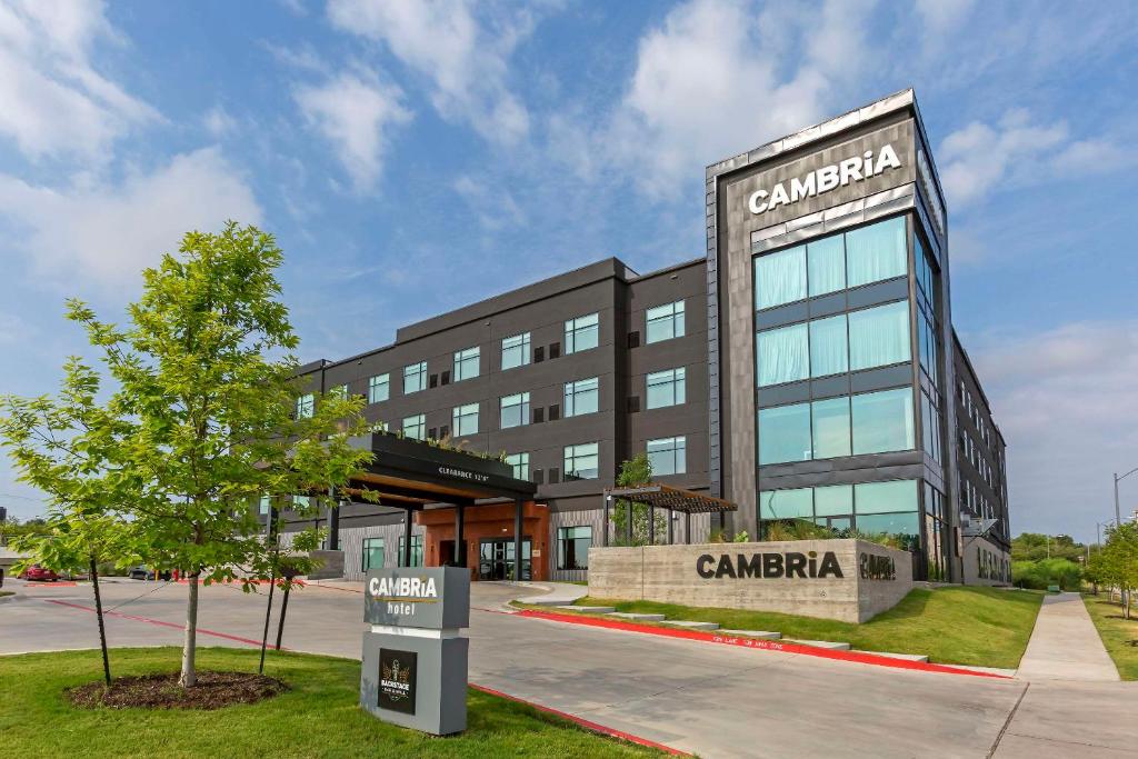 a building with a tree in front of it at Cambria Hotel Austin Airport in Austin