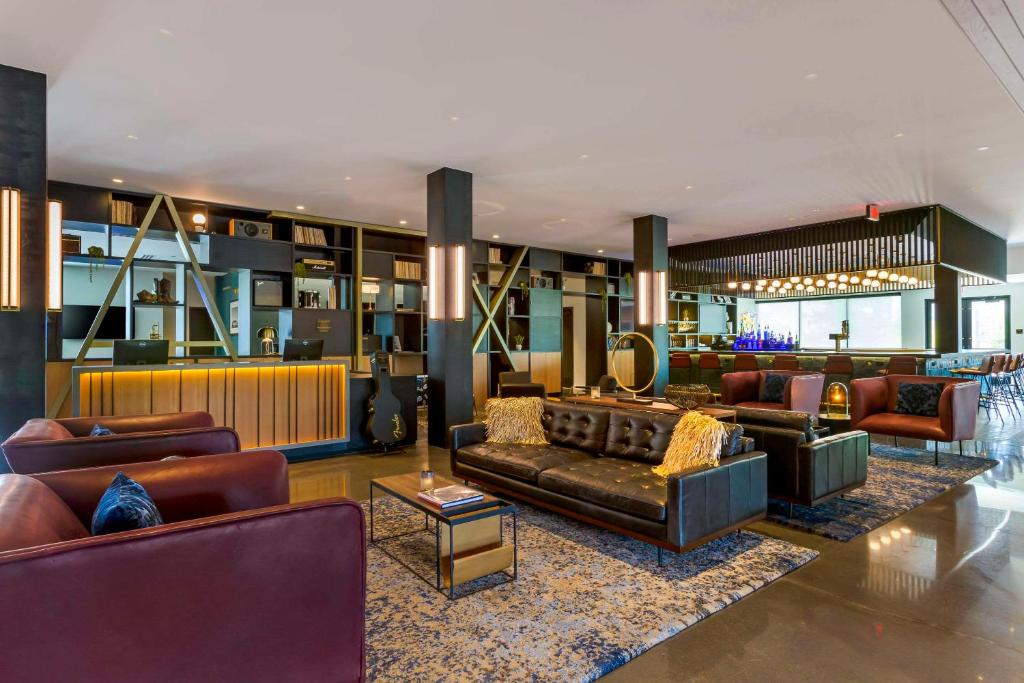 a lobby with leather couches and a bar at Cambria Hotel Austin Airport in Austin