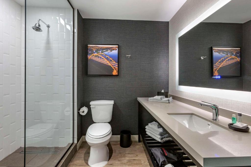 a bathroom with a toilet and a sink and a shower at Cambria Hotel Austin Airport in Austin