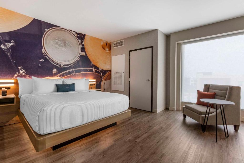 a bedroom with a bed and a table and a chair at Cambria Hotel Austin Airport in Austin