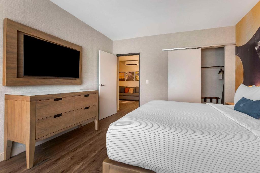a bedroom with a bed and a tv on the wall at Cambria Hotel Austin Airport in Austin