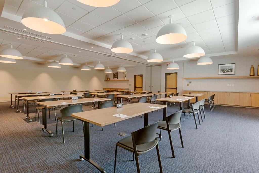 an empty classroom with tables and chairs and lights at Cambria Hotel Austin Airport in Austin