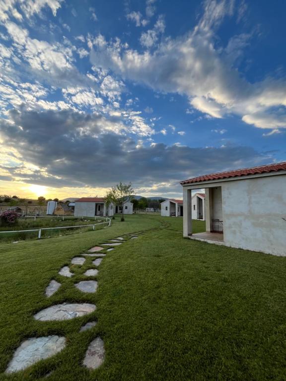 a grassy yard with a stone walkway at Casa Rural Granja Abril in Cardiel de los Montes