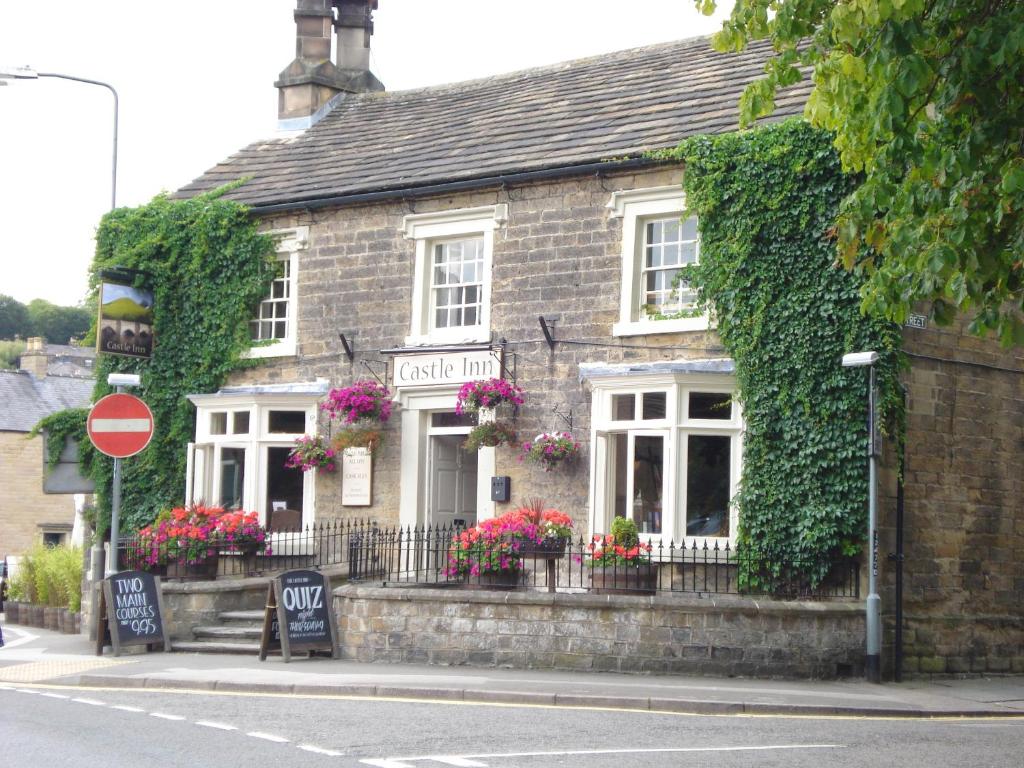 un edificio de ladrillo con flores delante en Castle Inn by Greene King Inns en Bakewell