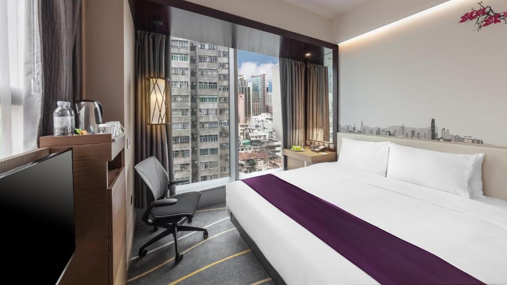 una camera d'albergo con un letto grande e una finestra di Hilton Garden Inn Hong Kong Mongkok a Hong Kong