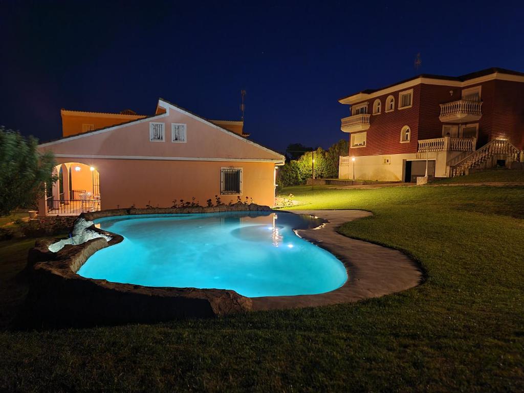 a swimming pool in front of a house at night at Finca SOTOMAR-casa rural Simancas in Simancas