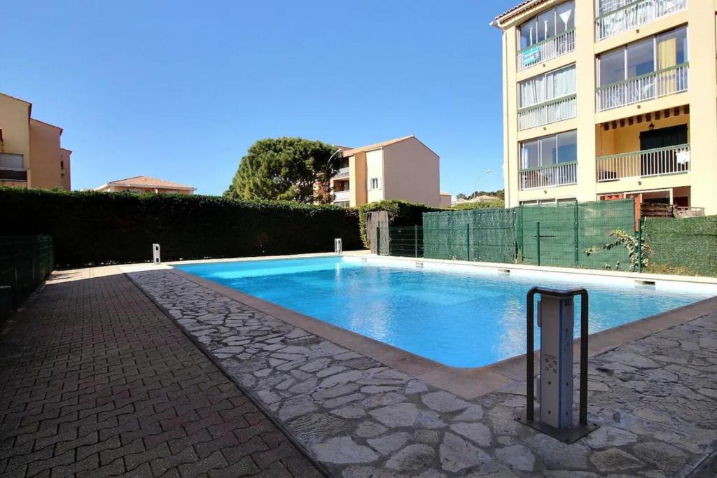 une piscine devant un immeuble dans l'établissement Studio with pool near the sea wifi and AC, à Sanary-sur-Mer