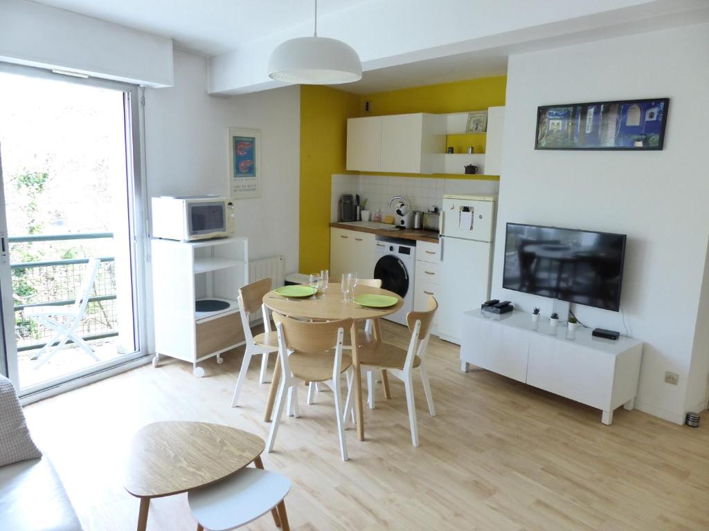 une cuisine et une salle à manger avec une table et des chaises dans l'établissement Chézine, T2 au calme avec balcon, 2pers et parking, à Nantes