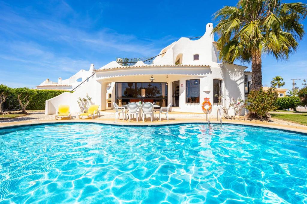 a villa with a swimming pool in front of a house at Villa Veiguinha in Galé