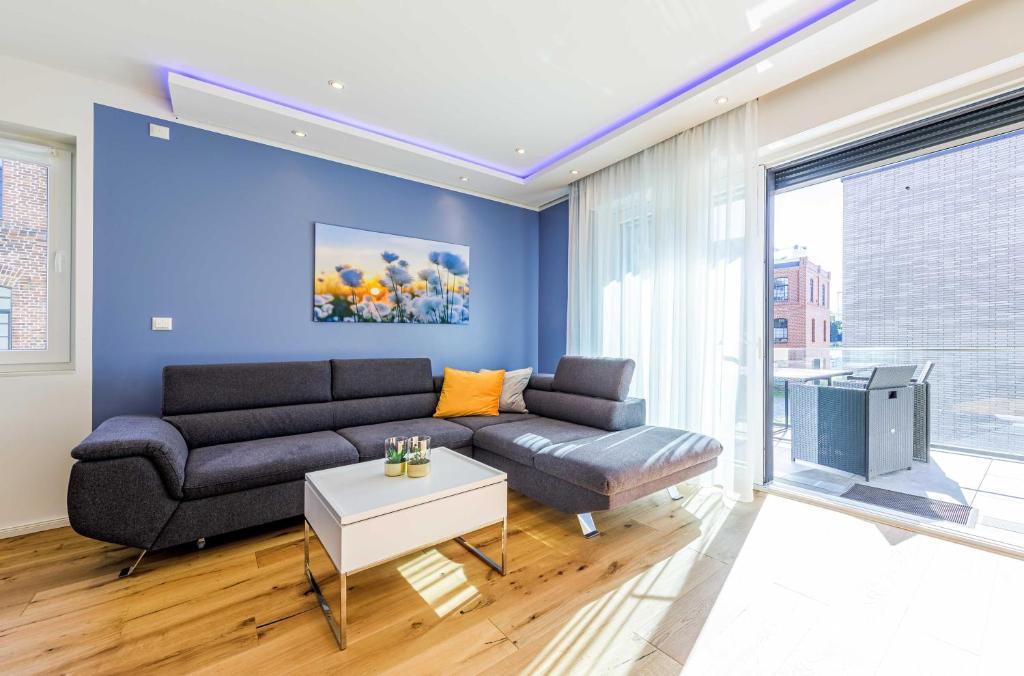 マルヒョーにあるSeeGlück Malchow - Stilvolle Maisonette mit Balkonen & Seeblickのソファとテレビのあるリビングルーム