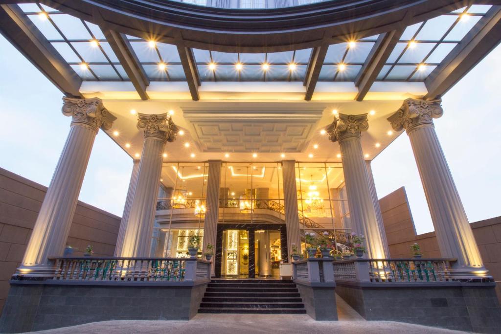a lobby of a building with columns and a staircase at d'Primahotel Bandung in Bandung