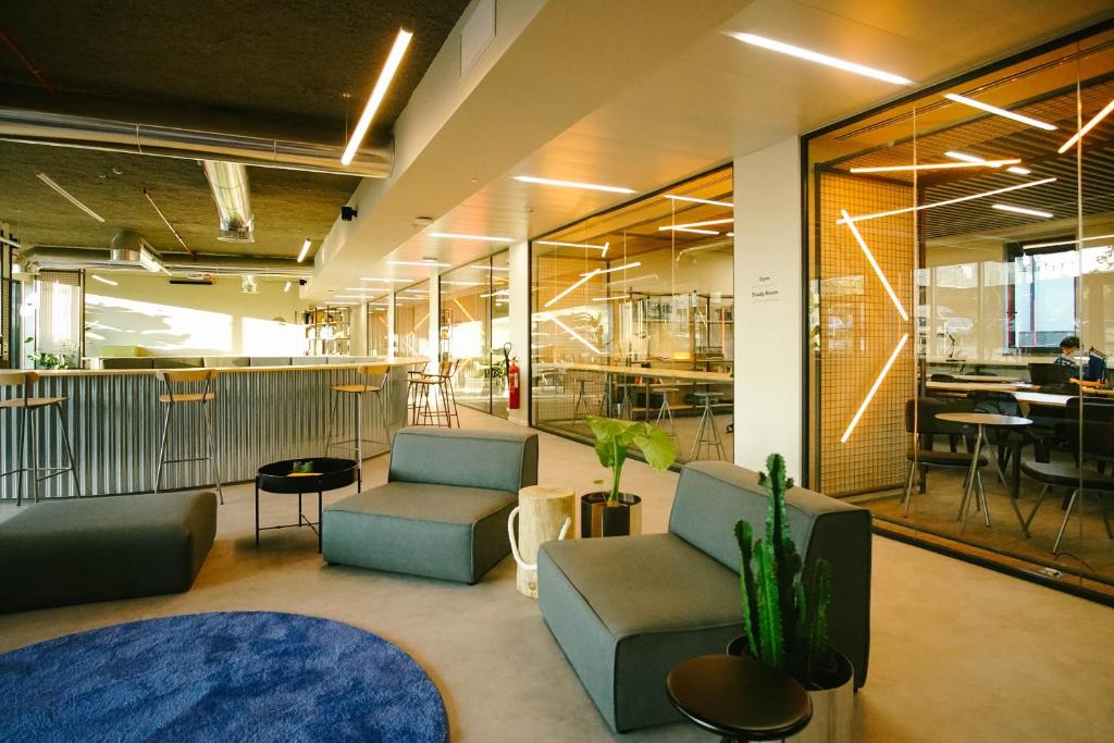 a lobby with couches and chairs in an office at Micampus Braga Student Residence in Braga