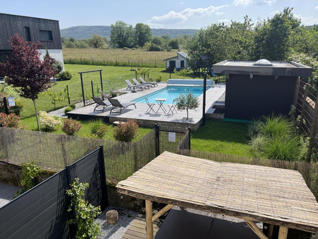 une arrière-cour avec une table en bois et une piscine dans l'établissement APPART-HOTEL n 3 avec terrasse, piscine, petit-dejeuner et parking privé, à Chouzelot