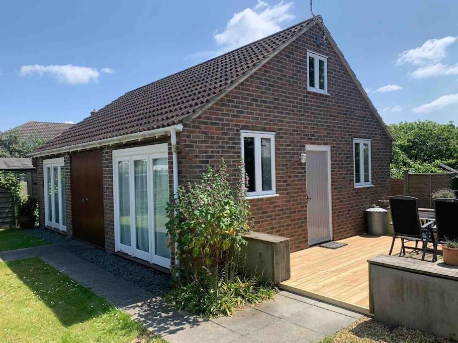a red brick house with a wooden deck at Beach Walk in Radipole