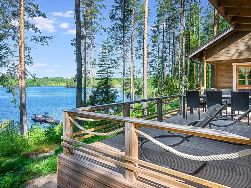 a large wooden deck with chairs and a house at Holiday Home Mäntykumpu by Interhome in Petäjävesi