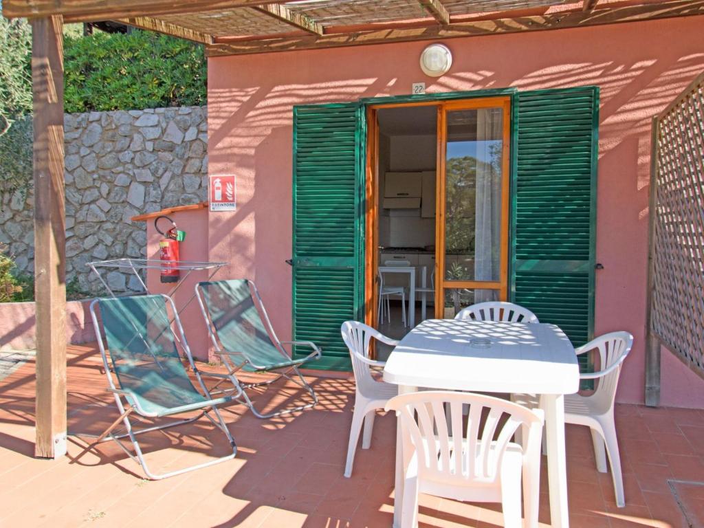 a patio with chairs and a table in front of a house at Apartment Elbamar Lacona I-2 by Interhome in Capoliveri