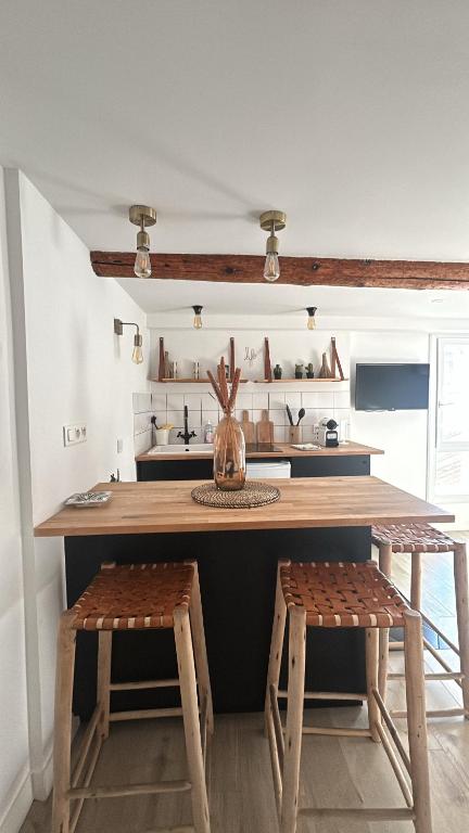 une cuisine avec un comptoir en bois et deux tabourets dans l'établissement Place aux huiles, à Marseille
