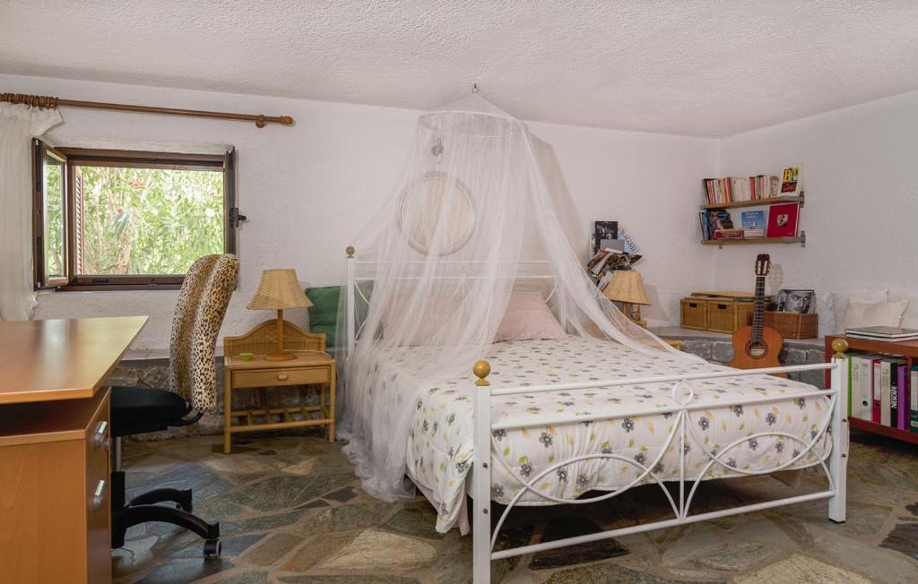 a bedroom with a bed with a mosquito net at Elise Cottage in Vathi