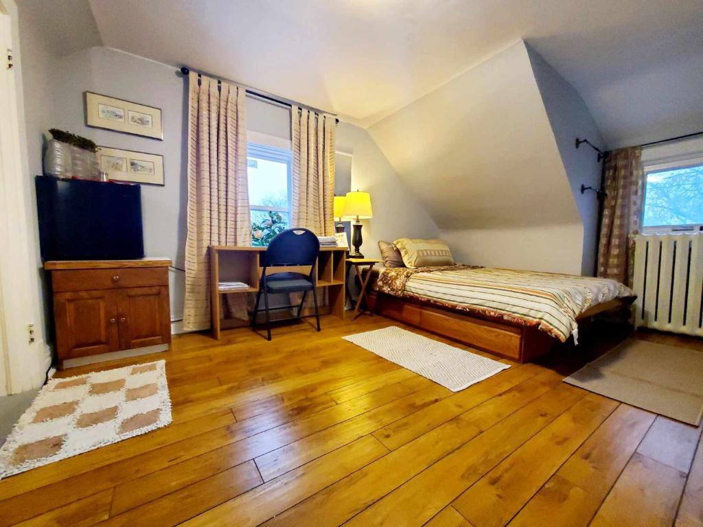 a bedroom with a bed and a desk with a chair at Merj's Guest House in Wolesly in Winnipeg