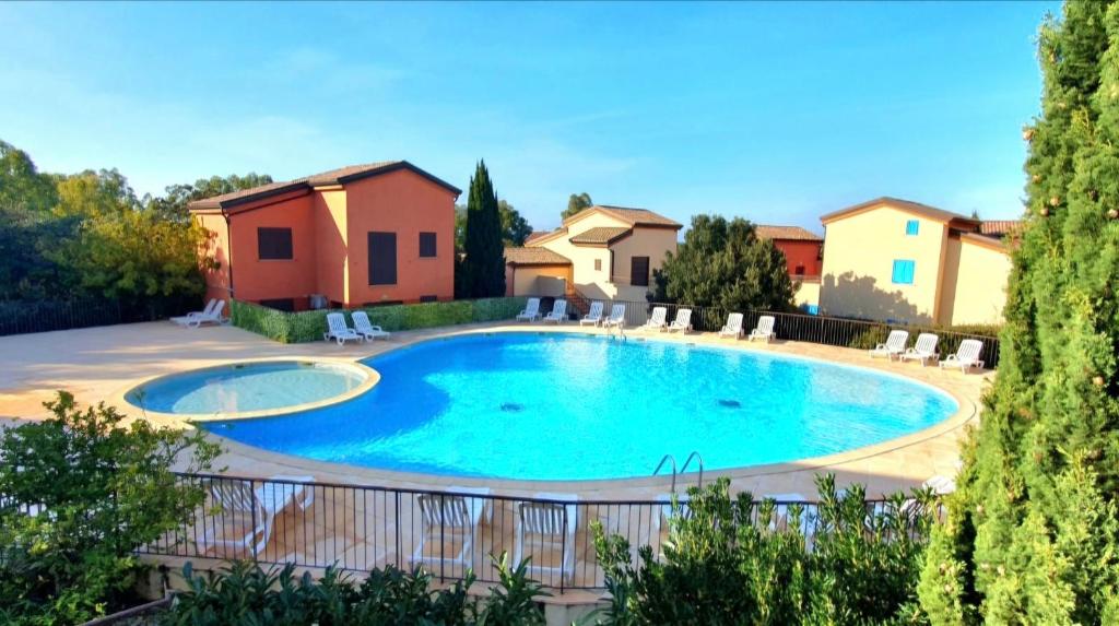 une piscine dans une cour avec des chaises et une maison dans l'établissement Immo A2L Lozari, à Belgodère