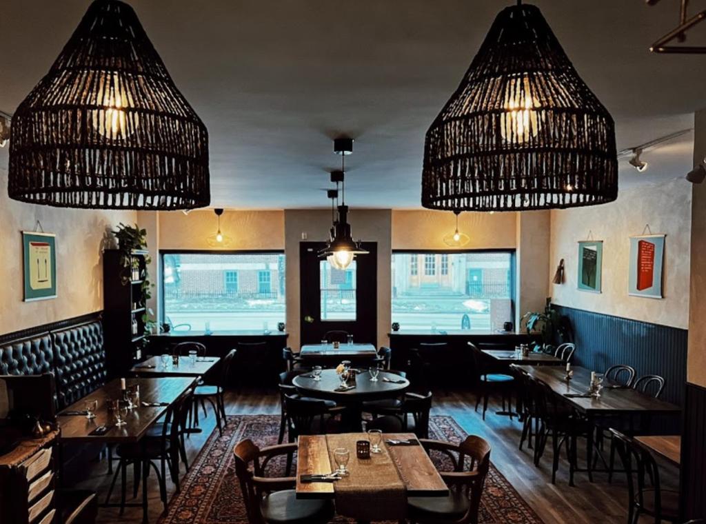 a restaurant with tables and chairs and chandeliers at Merj's Guest House in Wolesly in Winnipeg