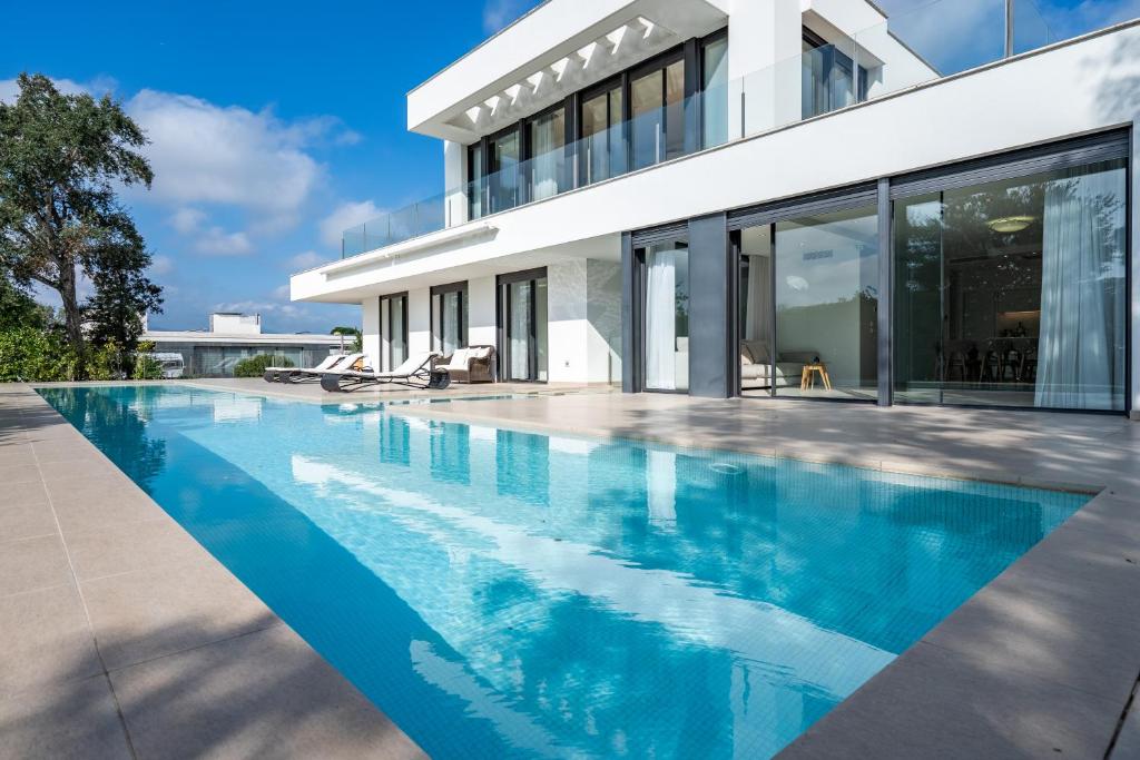 a swimming pool in front of a house at ViLLA LA SELVA PGA in Girona