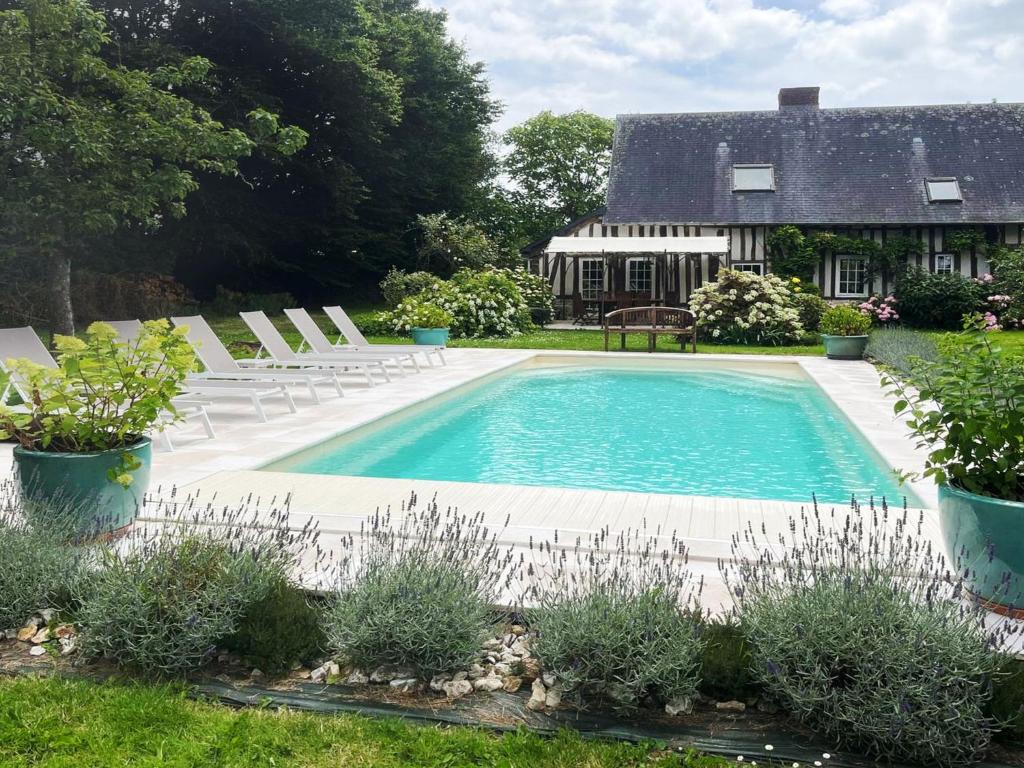 a swimming pool with chairs and a house at Holiday Home La longère by Interhome in Vatteville-la-Rue