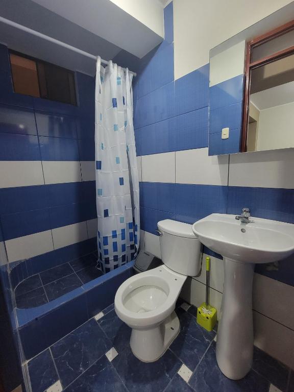 baño azul y blanco con aseo y lavabo en Hospedaje Escorpio, en Lima