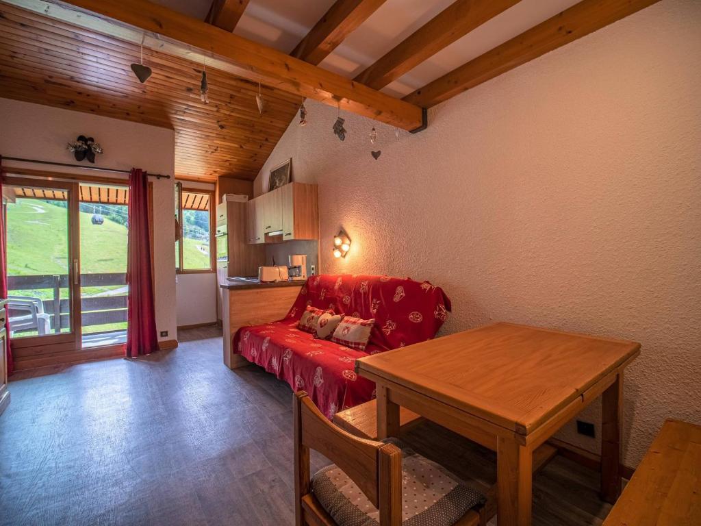 un salon avec un canapé rouge et une table dans l'établissement Appartement spacieux avec balcon, animaux acceptés - Valmorel - FR-1-356-298, à Valmorel