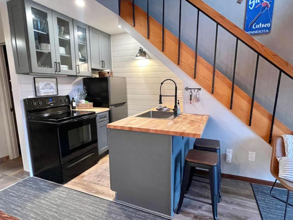 una cocina con fregadero y fogones y una escalera en Ski in Ski out 1 Bed plus Loft BEST VIEWS IN LUTSEN, en Lutsen
