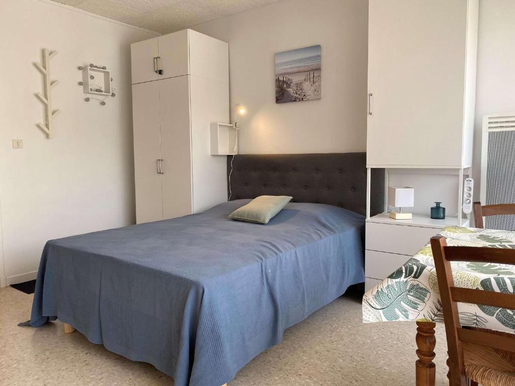 - une chambre avec un lit bleu et une armoire blanche dans l'établissement Studio confortable face aux Thermes avec balcon - FR-1-553-26, à Balaruc-les-Bains