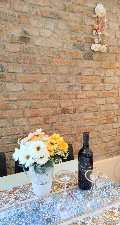 une table avec une bouteille de vin et un vase de fleurs dans l'établissement Conchiglia Magica Golfo dei Poeti, à La Spezia