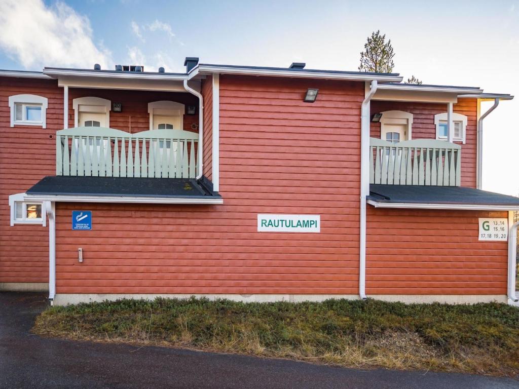 a red building with a balcony on the side of it at Holiday Home Rautulampi g14 by Interhome in Saariselka