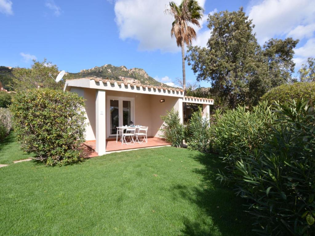a small house with a patio and a lawn at Holiday Home Mirto Marino-4 by Interhome in Costa Rei